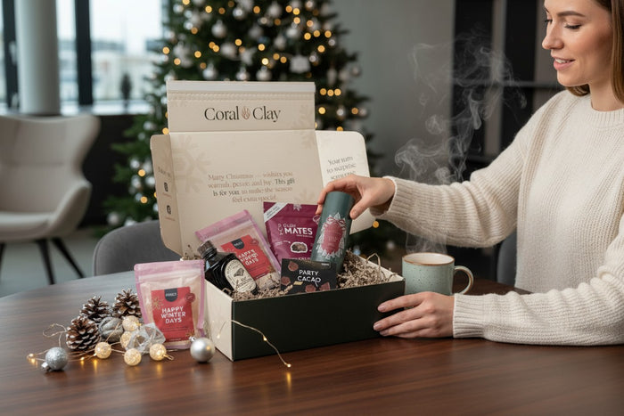 Employee opening a Coral & Clay Christmas gift in an office with a Christmas tree