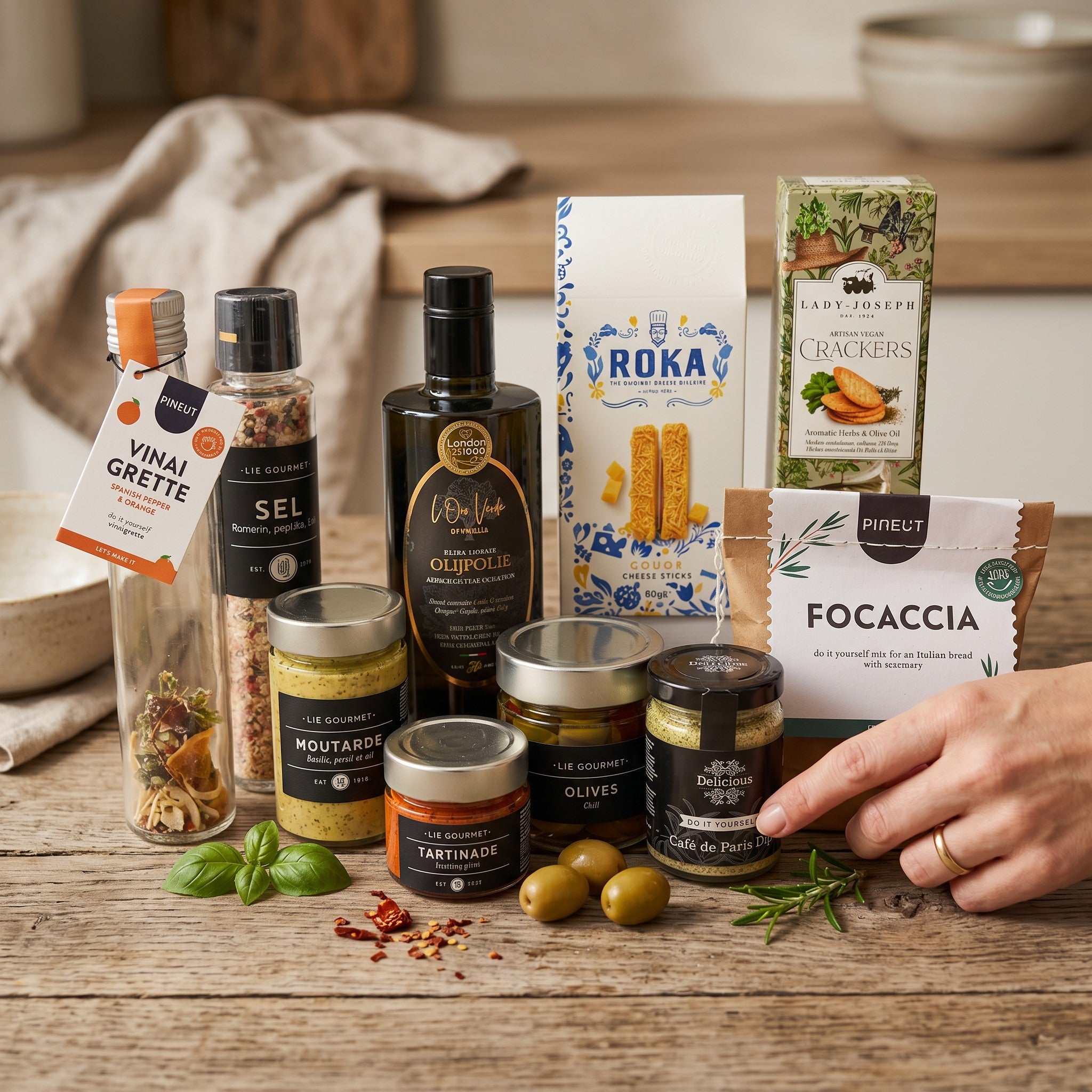 Assorted food products including olive oil, olives, and crackers on a wooden surface.