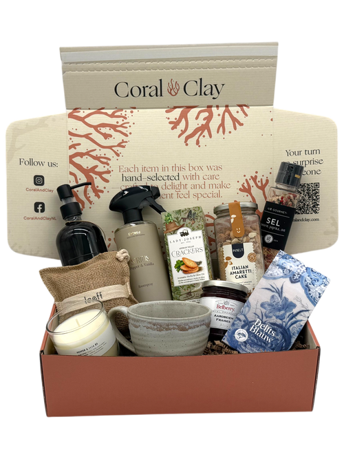 Cadeaubox met diverse items, waaronder een mok, zeep en badproducten op een witte achtergrond.