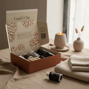 Coral & Clay signature gift box open on a table with a candle and vase in the background