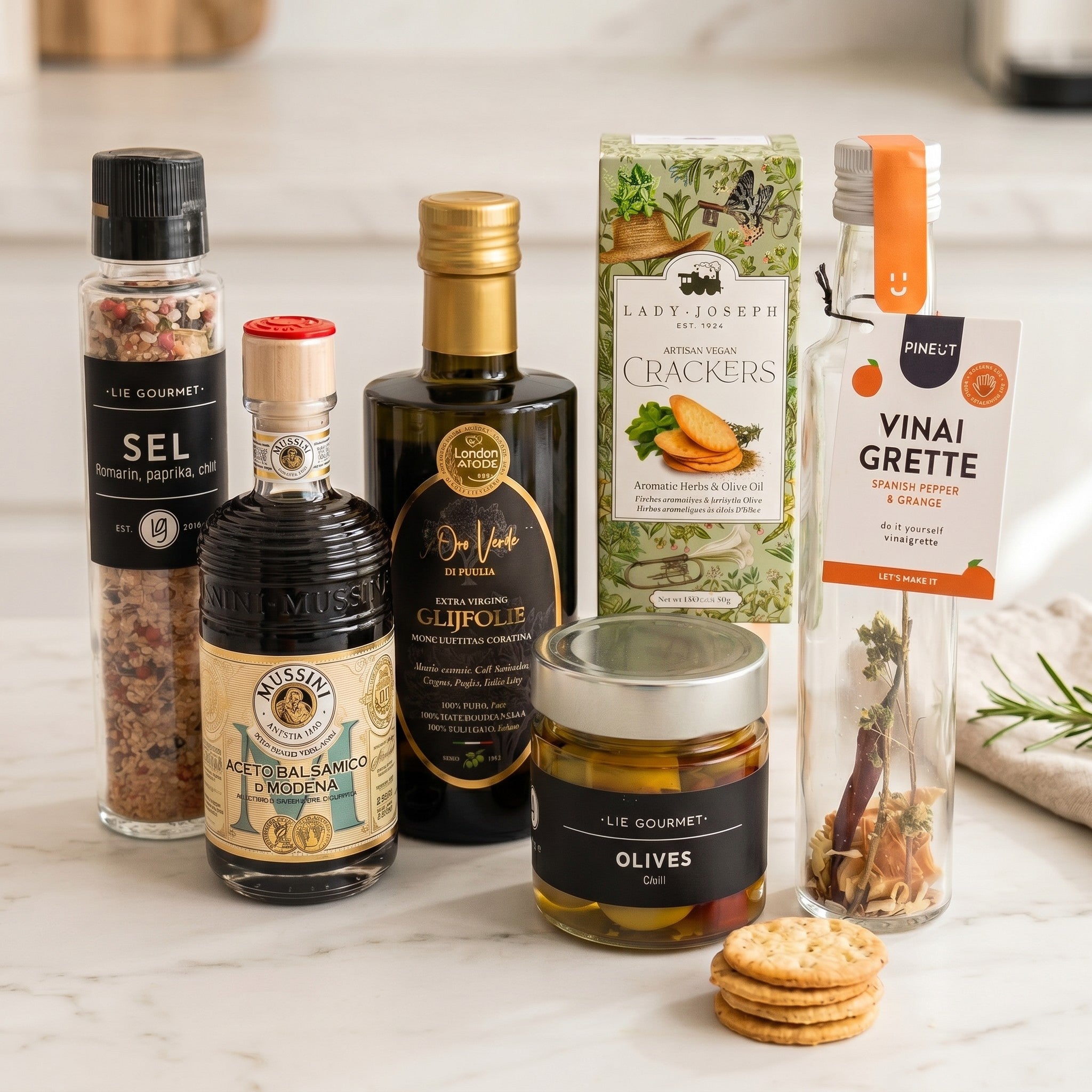 Luxury Mediterranean Signature Gift items on countertop: Puglia olive oil, balsamic vinegar, olives, crackers, vinaigrette and seasoning grinder.