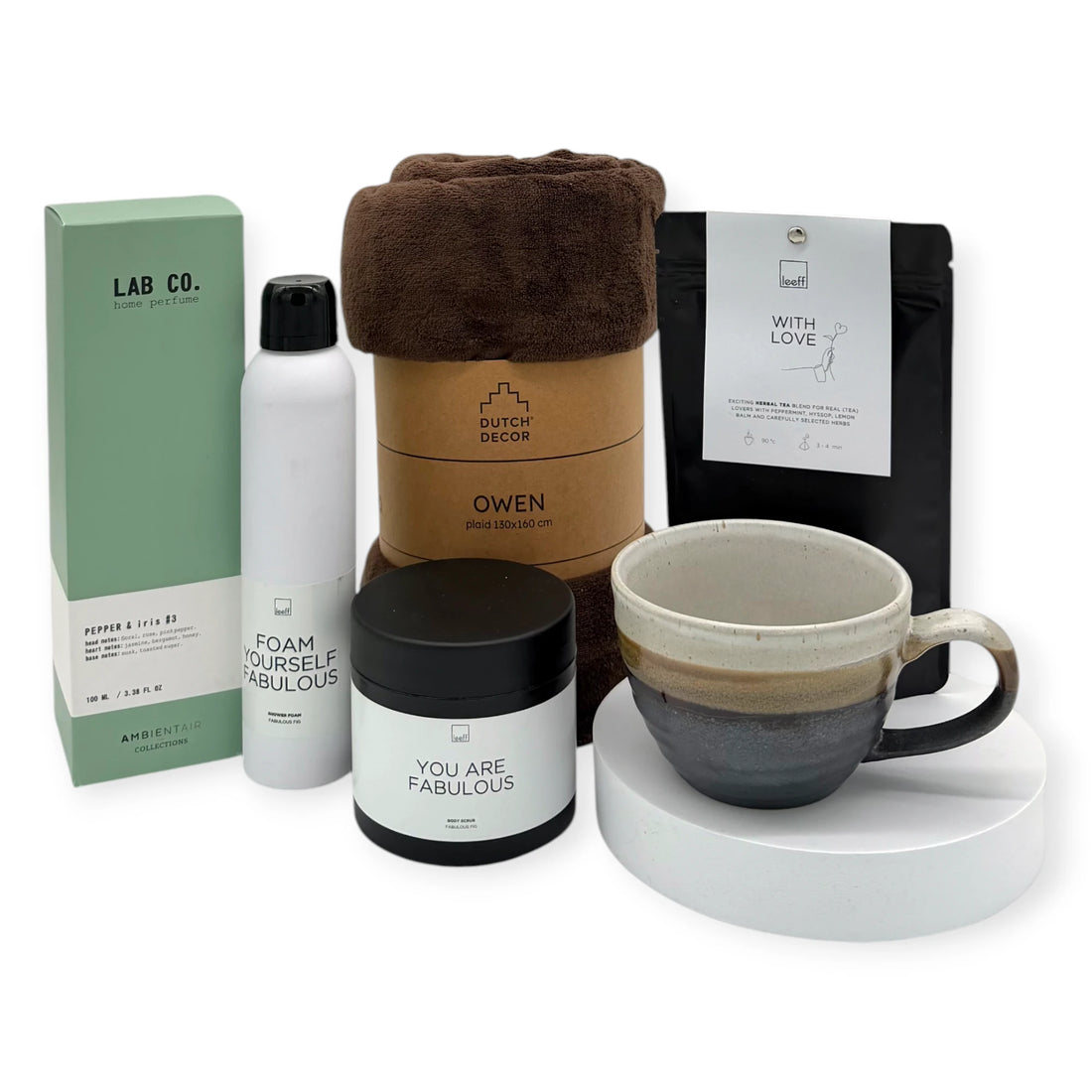 The Coral & Clay Grand Body & Mind Gift Box displayed with all items arranged around the signature terracotta gift box, featuring a brown cozy blanket, artisan ceramic mug, Leeff ‘With Love’ tea, Leeff shower foam and body scrub, and Lab Co. home perfume.