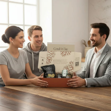 Business person giving young couple a Coral & Clay corporate gift box.