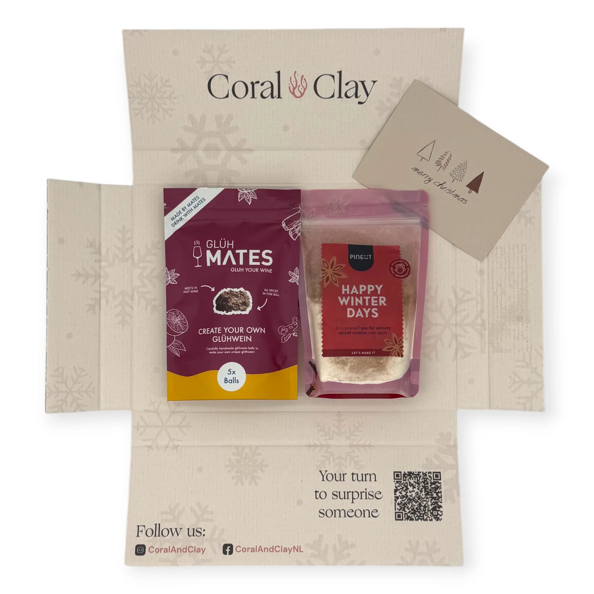 Alt text: Top-down view of the Coral & Clay Winter Warmth Christmas Letterbox Gift opened to show Glüh Mates glühwein mix and Pineut Happy Winter Days cookie mix inside the festive printed box.