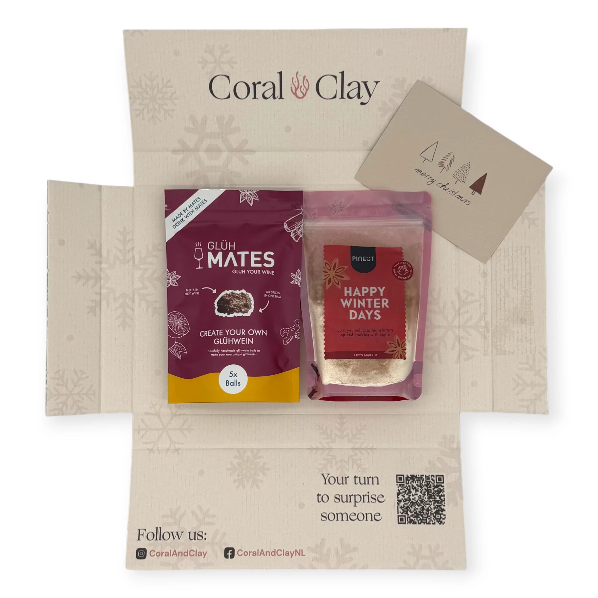 Alt text: Top-down view of the Coral & Clay Winter Warmth Christmas Letterbox Gift opened to show Glüh Mates glühwein mix and Pineut Happy Winter Days cookie mix inside the festive printed box.