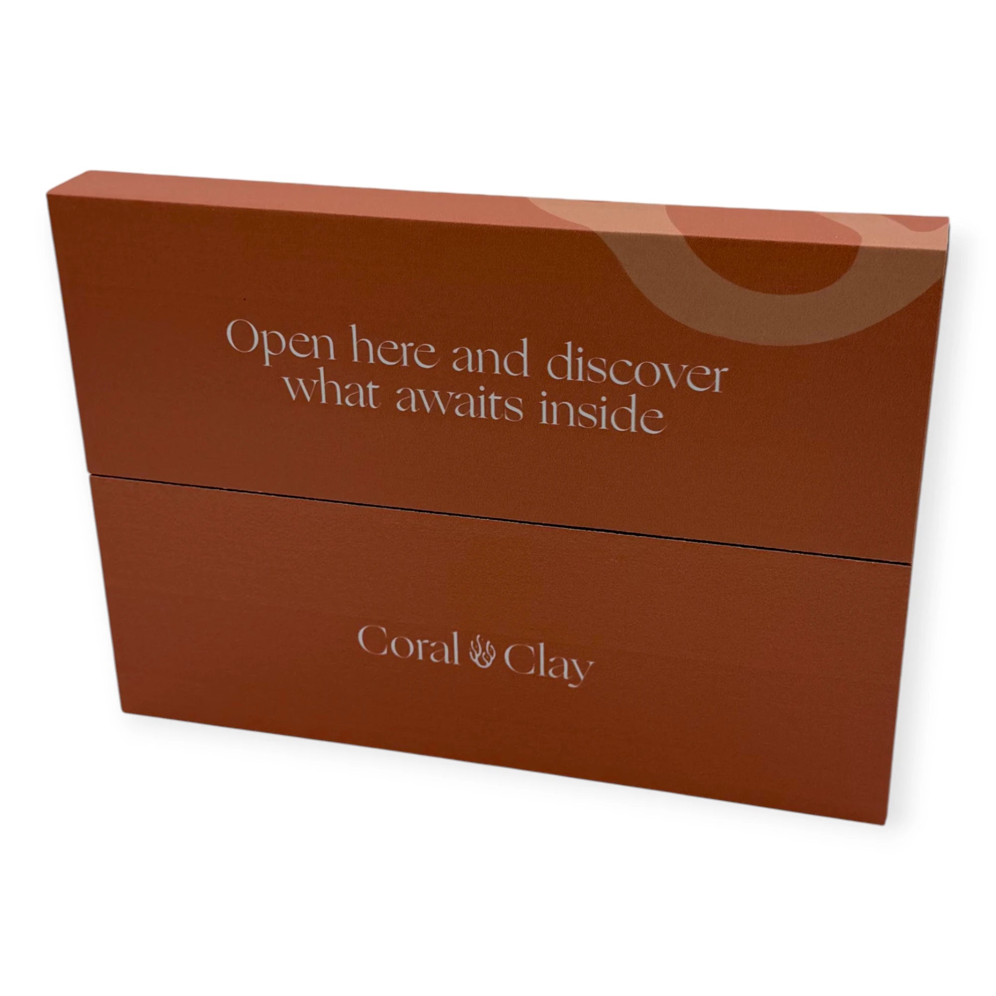 Back of the Coral & Clay letterbox gift packaging showing the message “Open here and discover what awaits inside” and the brand logo.