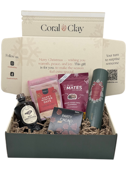 Cadeaubox met diverse items, waaronder een fles, zakjes en een bus, met ‘Coral Clay’-logo.