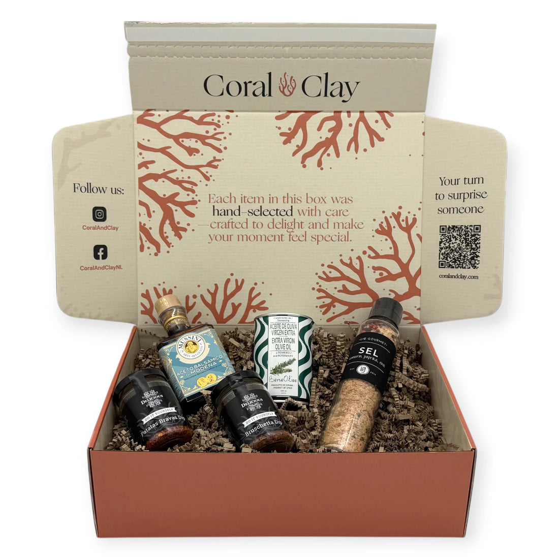 Gourmet cooking ingredients displayed in front of a Coral & Clay signature gift box, including Lie Gourmet seasoned salt, Mussini balsamic vinegar, Beneoliva rosemary extra-virgin olive oil, and two Delicious dip jars.