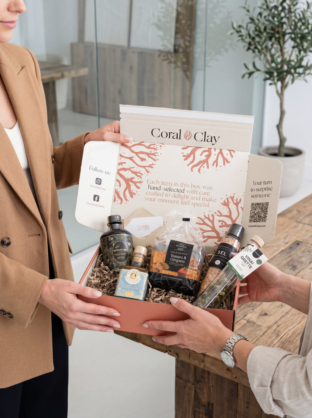 Zakelijke klant die een Coral & Clay-cadeaubox in huisstijl ontvangt in een professionele omgeving