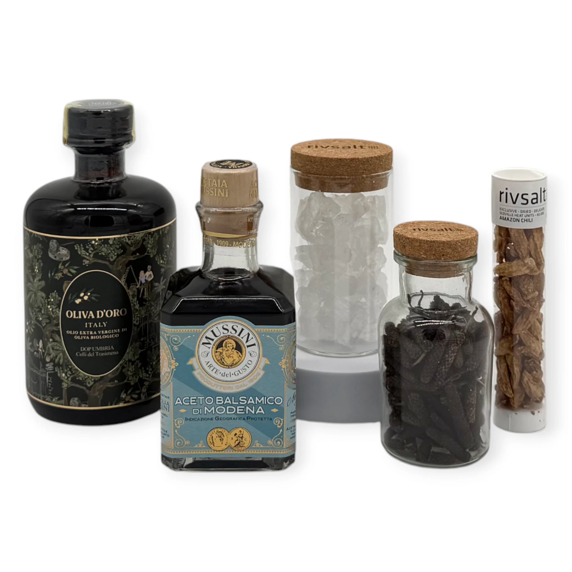 Premium Kitchen Essentials Signature Gift Box contents including Oliva d’Oro Italian extra-virgin olive oil, Mussini balsamic vinegar, Rivsalt crystal salt rocks, Rivsalt Amazon chili, and glass jars filled with long pepper and salt crystals.