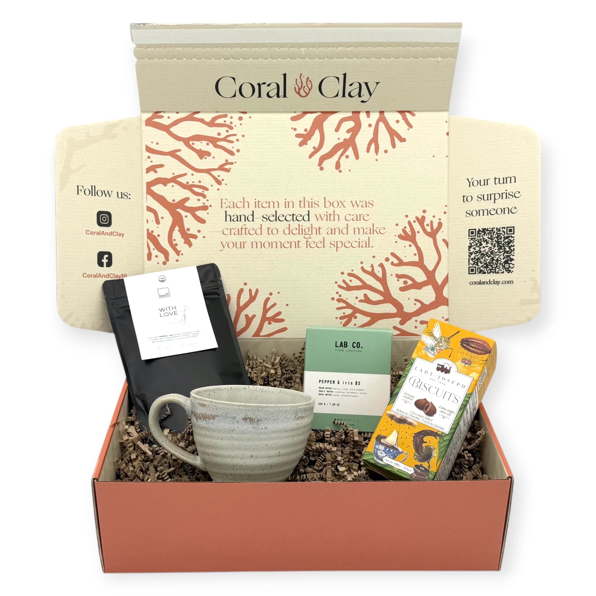Open Coral & Clay Tea Time Signature Gift displayed with crinkle paper, showing herbal tea, home perfume, biscuits, and a ceramic mug in a warm lifestyle setting.