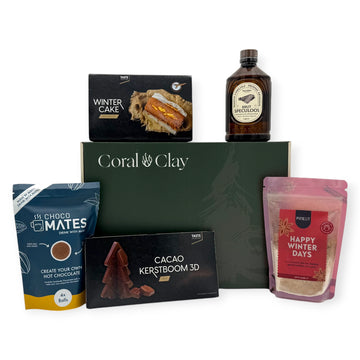 Coral & Clay Winter Sweets Signature Gift Box in deep green with all products arranged around it: Winter Cake mix, Speculoos liqueur, Choco Mates hot chocolate balls, Happy Winter Days cookie mix, and 3D milk chocolate Christmas tree.